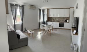 een keuken en een woonkamer met een bank en een tafel bij Kouzoulis House in Éxo Khóra