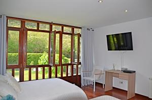 Un dormitorio con una cama y un escritorio y una ventana. en Villa La Atalaya, en Llanes 20 fotos más