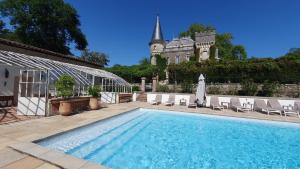 une piscine avec des chaises et un bâtiment en arrière-plan dans l'établissement Château Belle Epoque - Chambres d'Hôtes & Gîtes, à Linxe