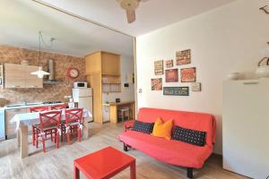 a living room with a red couch and a kitchen at VOLTA Pool&Beach apartment in Bardolino