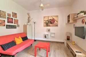 a living room with a red couch and a flat screen tv at VOLTA Pool&Beach apartment in Bardolino