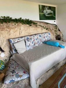 een bed met kussens in een kamer bij Una Finestra sul Mare in Augusta