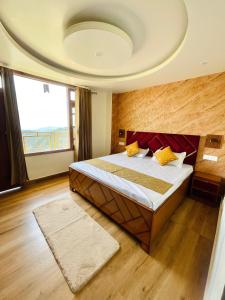 a bedroom with a bed and a large window at Aammk homes in Shimla