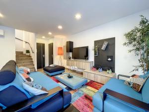 a living room with two blue couches and a tv at Les villas du Golf Mougins in Mougins