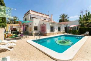 a swimming pool in front of a house at CM Azibi Blue Room in El Campello