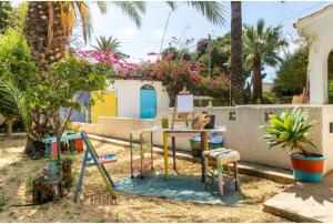 einen Tisch und Stühle in einem Garten mit einem Zaun in der Unterkunft CM Azibi Blue Room in El Campello