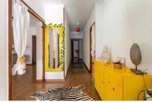 a living room with a yellow dresser and a room with a zebraebra at CM Azibi Blue Room in El Campello +4 photos