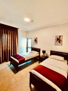 um quarto de hotel com duas camas e uma janela em Tamrah Suites Hotel em Amã