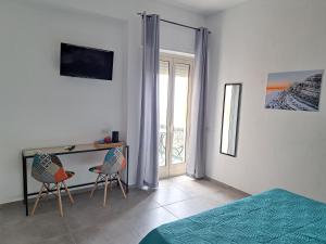 a bedroom with a bed and a desk with two chairs at B&B Gergent in Agrigento