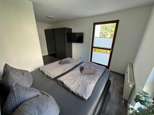 - une chambre avec 2 lits et une fenêtre dans l'établissement FHV01 - Ferienwohnung 100m² 6 Personen Garten und Terrasse 2x WC, à Taucha