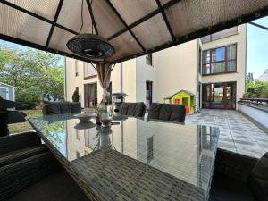 an outdoor dining table with a glass table top at FHV01 - Ferienwohnung 100m² 6 Personen Garten und Terrasse 2x WC in Taucha