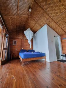 a bed in a room with a wooden ceiling at Treetop Guesthouse and Bungalows in Sabang