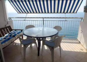 una mesa y sillas en una habitación con vistas al océano en Ely Palace, vistas al mar/4pax en Platja  d'Aro