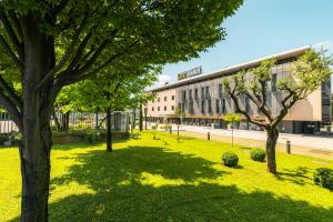 a park with trees in front of a building at One Hotel & Restaurant in Dalmine