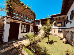 uma casa com uma porta preta e um quintal em KRIS Guesthouse em Berat