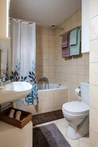 a bathroom with a tub and a toilet and a sink at Pepe home in Nafplio