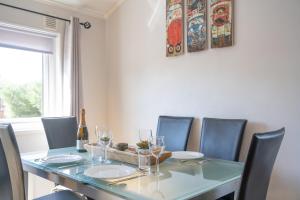 a dining room table with chairs and a bottle of wine at 4 Meadow View in West Down
