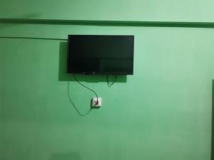 uma televisão de ecrã plano pendurada numa parede em Kashmir premium hotel em Narul