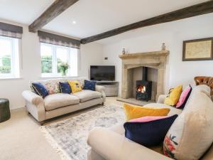 a living room with two couches and a fireplace at Sycamore Cottage in Ashbourne