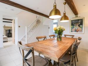 a dining room with a wooden table and chairs at Sycamore Cottage in Ashbourne