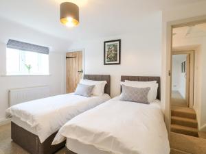 two beds sitting next to each other in a bedroom at Sycamore Cottage in Ashbourne