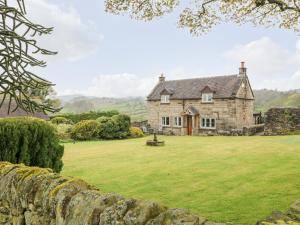 an old stone house with a large yard at Sycamore Cottage in Ashbourne