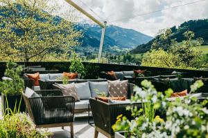 a patio with a couch and chairs and mountains at Grand Tirolia Kitzbühel - Member of Hommage Luxury Hotels Collection in Kitzbühel