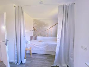 um quarto com uma cama branca com cortinas em Beach inkl WLAN em Grömitz