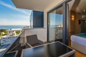 a room with a balcony with a view of the ocean at Villa Luna-Private Heated Pool and sauna in Novalja