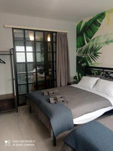 - une chambre avec un grand lit et une grande fenêtre dans l'établissement Patras' Hitech Apartment, à Patras
