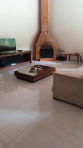 a living room with a fireplace and a couch at CASA LUXO-água quente-banheira-lareira-cachoeira. in Pedra Azul