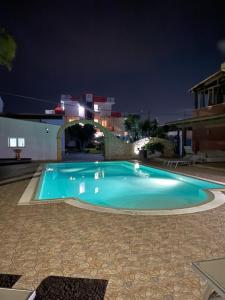 a large blue swimming pool at night at Hotel Rainbow Resort in Marsala