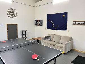 a ping pong table in a living room with a couch at Denali Park View House in Healy