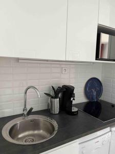 a kitchen counter top with a sink in a kitchen at CAP COZ Plage in Fouesnant