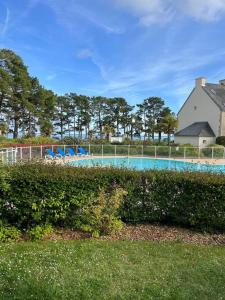 a large swimming pool in a yard with bushes at CAP COZ Plage in Fouesnant +16 photos