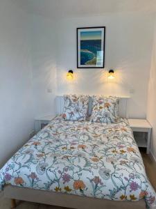 富埃南的住宿－CAP COZ Plage，卧室内的一张床位,墙上有两盏灯