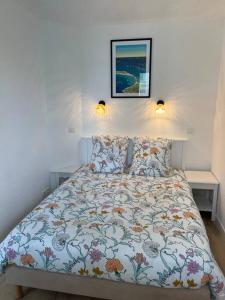 1 cama en un dormitorio con 2 lámparas en la pared en CAP COZ Plage, en Fouesnant