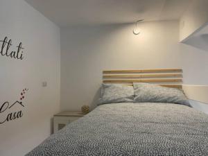 1 dormitorio con 1 cama con cabecero de madera en loft piccola londra, en Roma