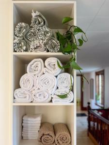 uma prateleira cheia de toalhas enroladas num quarto em Chez Léo par Maison Dudley em Lac-Mégantic