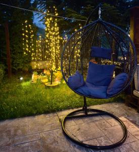 una sedia a dondolo in un cortile con luci di Pensiunea Constanta a Predeal