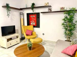 salon z żółtym krzesłem i telewizorem w obiekcie Acogedor y tranquilo cerca de las setas - centro w Sewilli