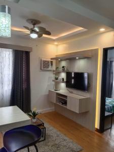 ein Wohnzimmer mit einem Flachbild-TV an der Wand in der Unterkunft Mesaverte Residences T2-8H in Cagayan de Oro