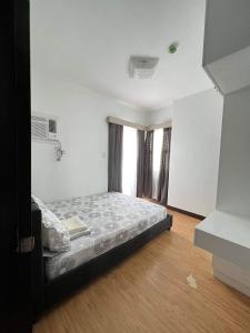 ein Schlafzimmer mit einem Bett in einem Zimmer in der Unterkunft Mesaverte Residences T2-8H in Cagayan de Oro