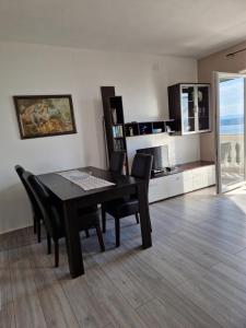 a dining room with a table and chairs and a kitchen at Apartments Velic in Crikvenica