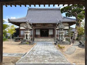 un templo asiático con una pasarela delante de él en shukubo michiru 満行寺 en Hagi