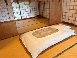 um quarto com uma cama no meio de um quarto em shukubo michiru 満行寺 em Hagi