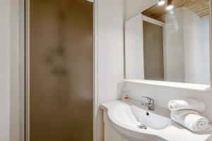 Baño blanco con lavabo y espejo en Luminous studio in the center of Avignon - Welkeys, en Aviñón