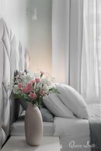 un jarrón de flores sentado en una mesa junto a un sofá en Platinum Suites, en Cracovia