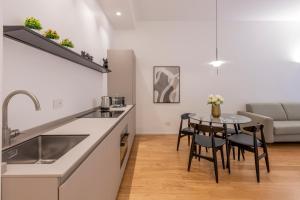 a kitchen with a sink and a table with chairs at Milan Royal Suites Duomo in Milan