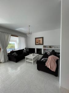 a living room with two black couches and a table at Villa Garrido in Portocolom